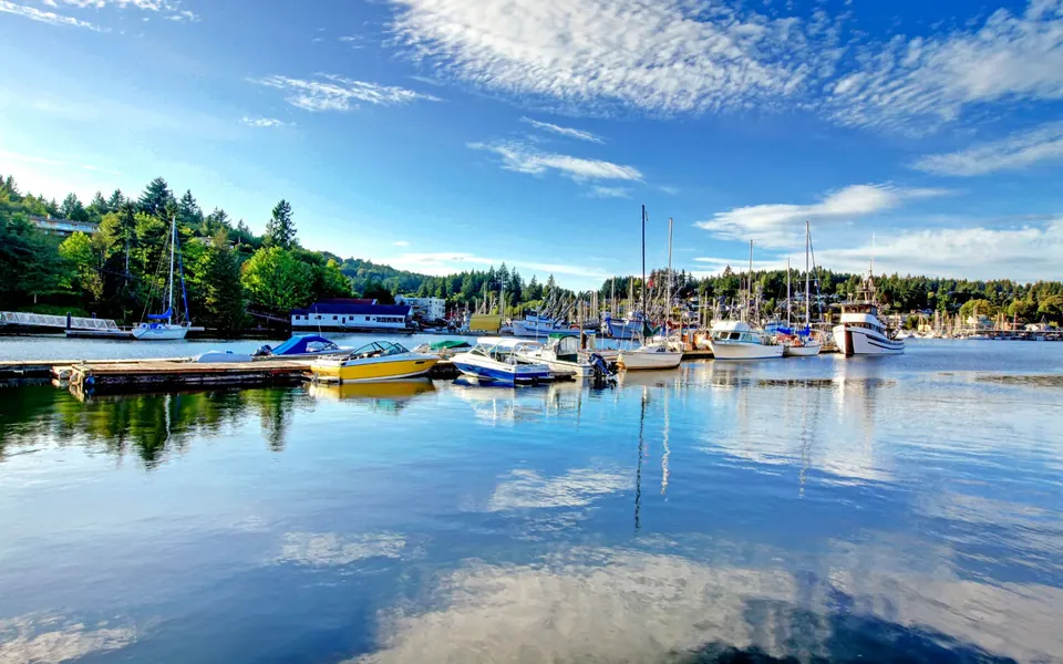 Gig Harbor marina on a still morning, sailboats reflected in the water.